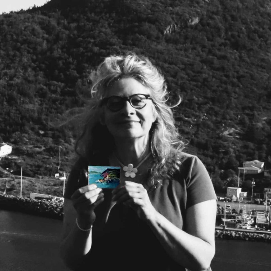 photo of Canadian landscape artist Irene Duma holding a mini painting